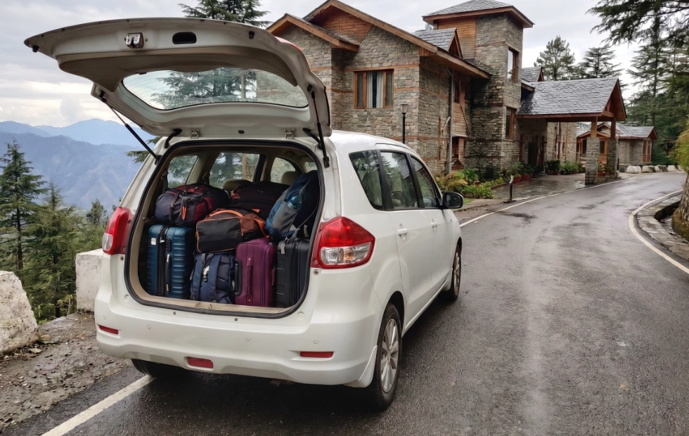 Happy family loading luggage into a spacious Maruti Suzuki Ertiga for a vacation from Coimbatore.