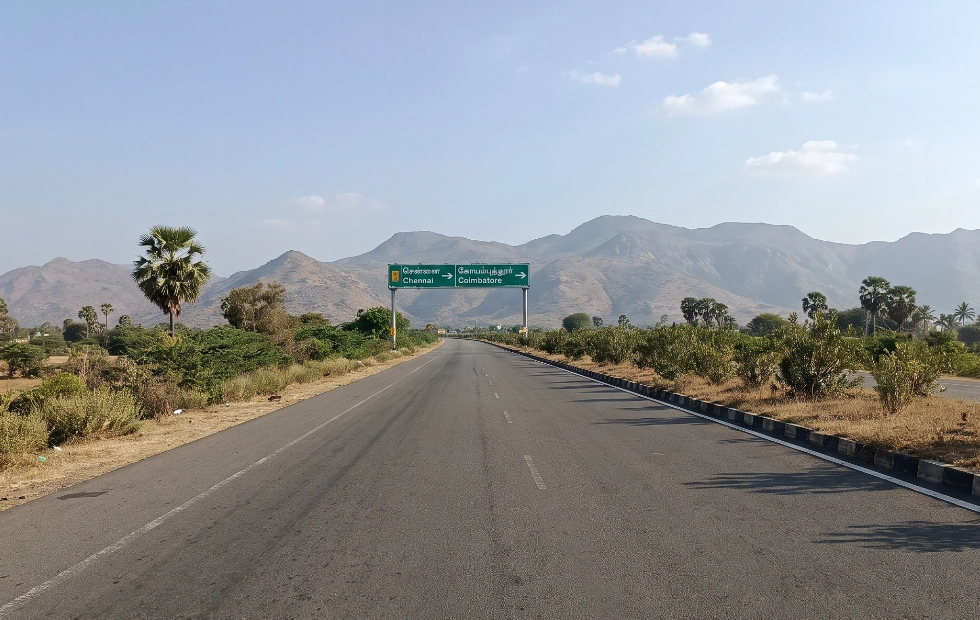 Maruti Ertiga tourist taxi parked on the highway for affordable one-way rental service from Coimbatore.