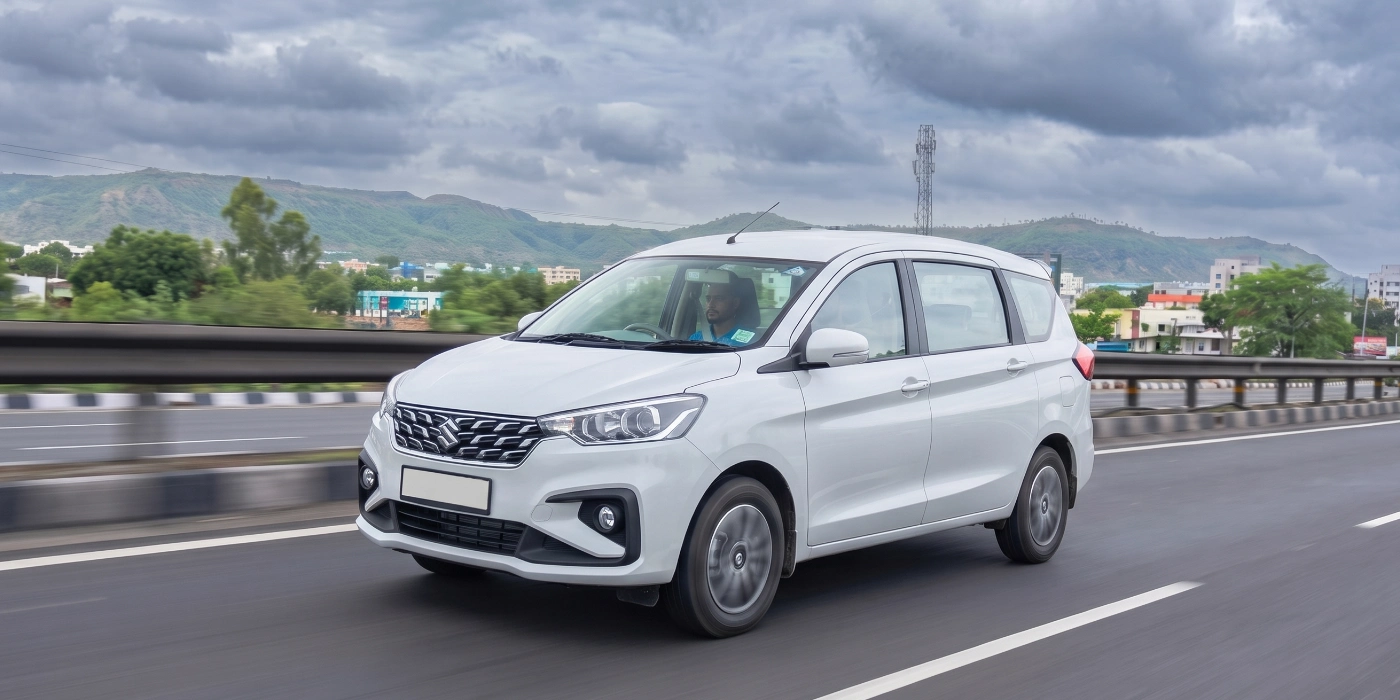 Silver Maruti Suzuki Ertiga 7 seater multi-purpose vehicle parked for rental services in Coimbatore